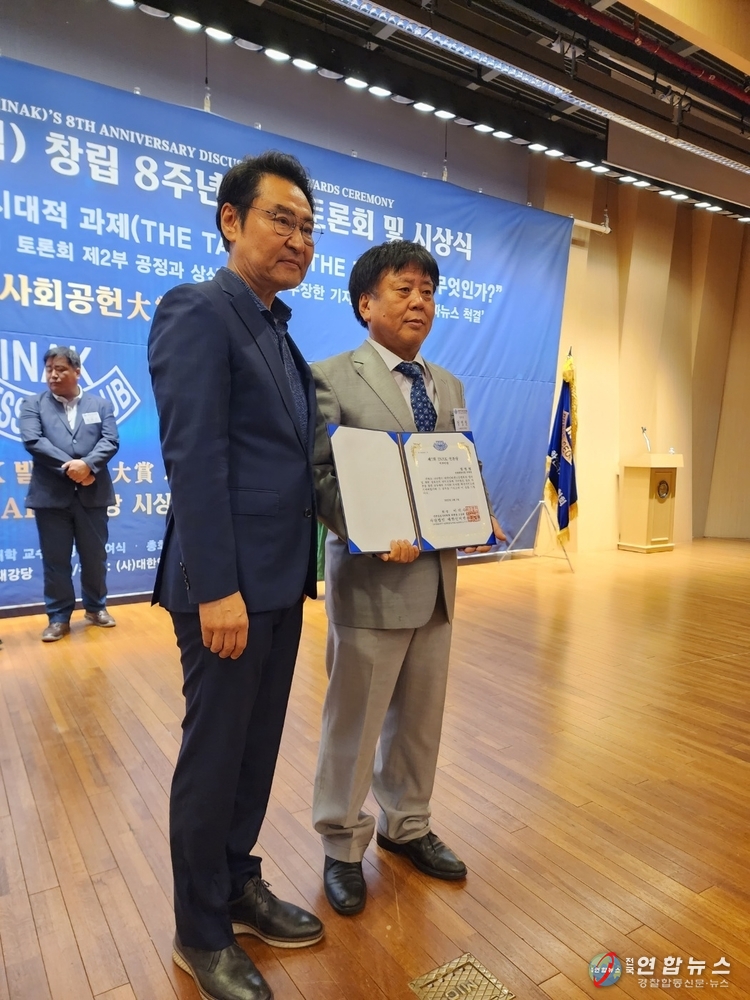정영일 경찰합동신문 부회장이 상장을 받고 포즈를 취하고 있다.