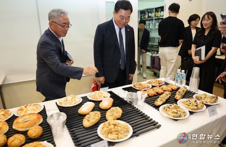 지난 7월 무안군-신세계푸드 협약식에서 무안 양파빵 제품을 살펴보는 김산 군수