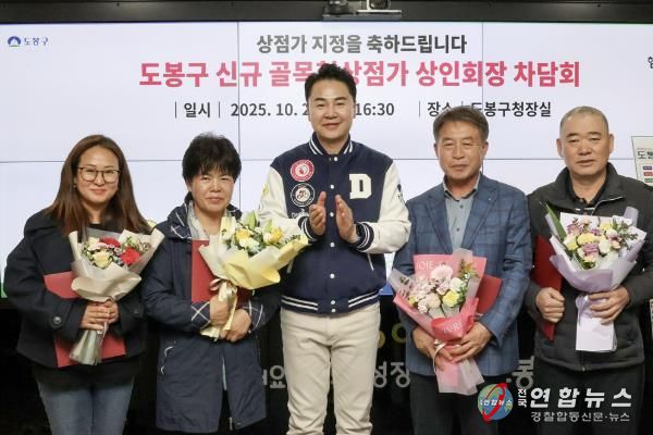 오언석 도봉구청장(가운데)과 이번에 새로 신규 지정된 골목형상점가 상인회장이 신규 지정을 기념하며 단체 사진을 찍고 있다