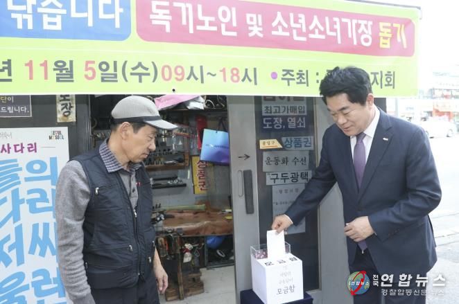 관악구 사랑의 구두닦이 행사에서 모금함에 기부하는 박준희 관악구청장