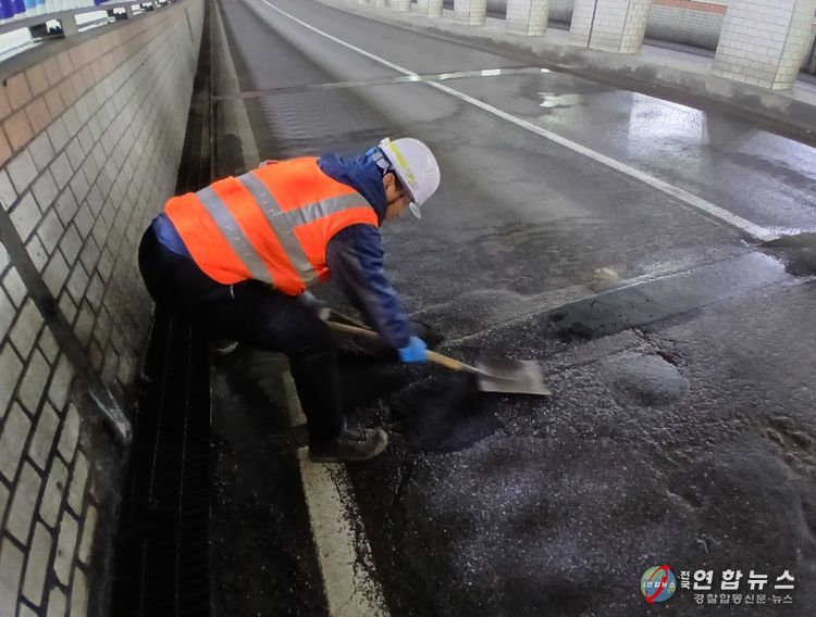 천안시 도로보수원들이 겨울철 폭설과 염화칼슘 영향으로 훼손된 도로 포트홀 구간에 아스콘을 충진하며 긴급 복구 작업을 진행하고 있다